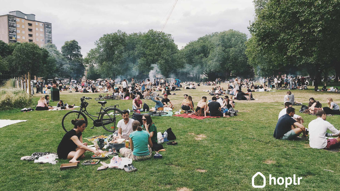 Neighbours gather in a park on a sunny afternoon